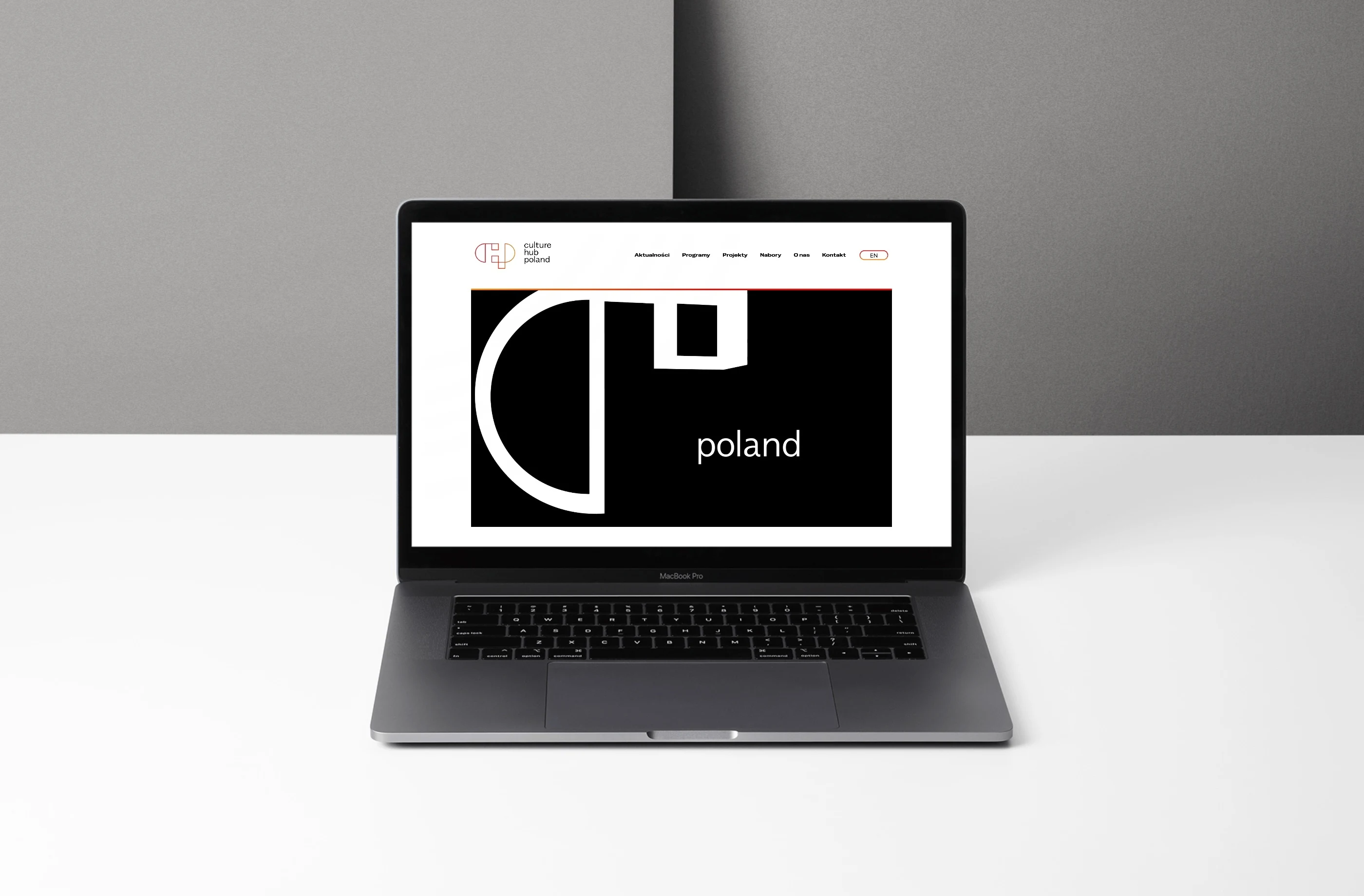 culturehubpoland.com — strona główna z animowanym sygnetem fundacji na laptopie